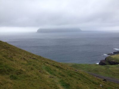 Mykines, on the other hand, the island that can be partially seen enveloped by fog in the picture, might be an objectively remote location on the globe --- it can only be reached by helicopter or boat, and under exceptionally good weather conditions --- the weather in the Faroe Islands changes often, dramatically, and rather unpredictably! (August '16)