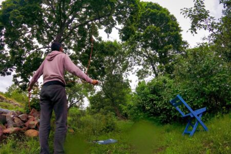 throwing a line to hang the shower bag on the tree